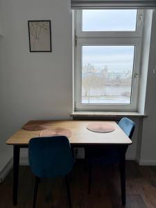 a table and two chairs in a room with a window at Stilvolle Wohnung mit Rheinblick in Weißenthurm +4 photos