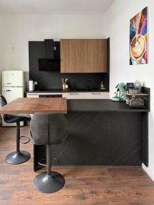a kitchen with a wooden table and two bar stools at Stilvolle Wohnung mit Rheinblick in Weißenthurm