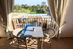 a table and chairs on a balcony with a view at Golden Land in ‘Ezbet Abu Ḥabashi