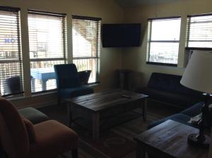 a living room with a couch and chairs and windows at Ocean Village Hotel in Surfside Beach +30 photos