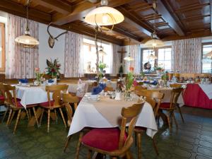 jadalnia ze stołami, krzesłami i oknami w obiekcie Gasthof Metzgerei Stöberl w mieście Lam