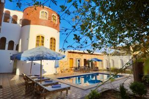 a pool with chairs and an umbrella next to a building at Golden Land in ‘Ezbet Abu Ḥabashi