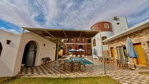 an external view of a house with a patio and a swimming pool at Golden Land in ‘Ezbet Abu Ḥabashi