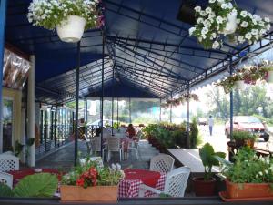 a patio with tables and chairs and potted plants at Complex Turistic Paralela'45 in Băicoi