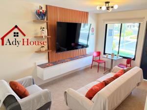 a living room with two white couches and a flat screen tv at AdyHouse Ziré in Buena Vista