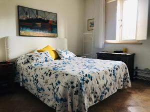 a bedroom with a bed with a blue and white comforter at Lo Squero Guest House in Fano