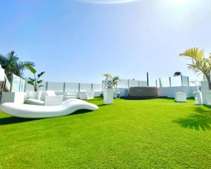 a living room with a white couch and green grass at Oasis Penthouse Maspalomas in Maspalomas