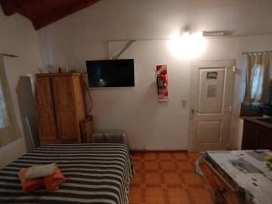 a bedroom with a bed and a television on the wall at La Serena Cabañas in Potrero de los Funes