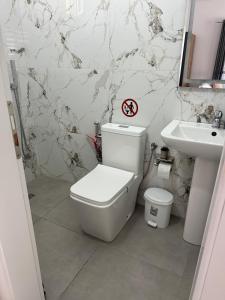 a bathroom with a white toilet and a sink at Lexhulo Room's in Domje +7 photos
