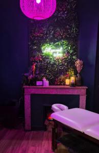 a room with a fireplace with a plant wall at Suite Passion - Jacuzzi privé - Table massage in Saint-Étienne