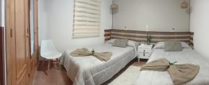 a room with two beds with towels on them at Casa Rural Exedra 3 Estrellas in Carcaboso