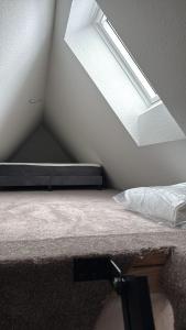 a bed in a room with a skylight at Auental in Husum