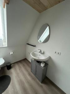 a bathroom with a sink and a mirror on the wall at Auental in Husum