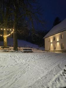 a white building with lights on it in the snow at Anna in Miłków