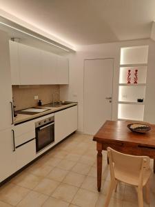 a kitchen with white cabinets and a wooden table at Borgo Piccolo in Imola