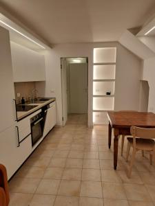 a kitchen with a wooden table and a tableasteryasteryasteryasteryasteryasteryastery at Borgo Piccolo in Imola +2 photos