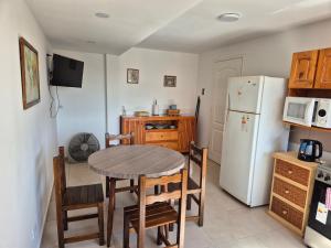 a kitchen with a table and a refrigerator at Rent Santa Clara in Santa Clara del Mar
