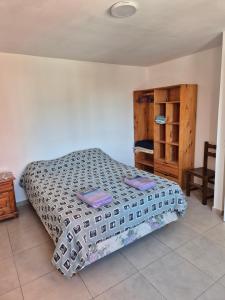 a bedroom with a bed and a wooden cabinet at Rent Santa Clara in Santa Clara del Mar