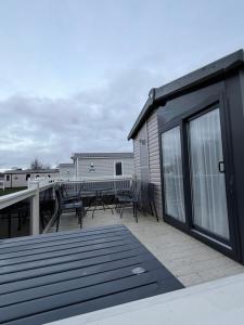 a deck with chairs and tables on a house at RelaxDream in Port Seton
