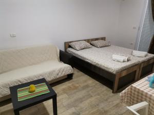 a room with two beds and a couch and a table at vila matejevic in Star Dojran