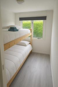 two bunk beds in a small room with a window at Moonlight Nature Holiday Home in Westergeest