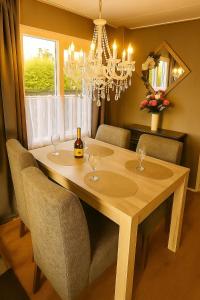 a dining room table with wine glasses and a chandelier at Moonlight Nature Holiday Home in Westergeest
