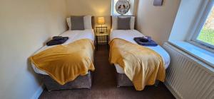 two beds sitting next to each other in a room at Hazeldene Cottage in Holmfirth