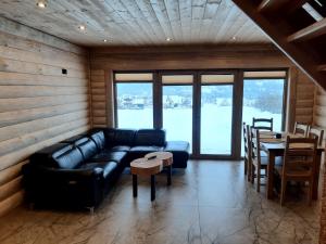 a living room with a leather couch and a table at Koziniec ski & chill in Czarna Góra