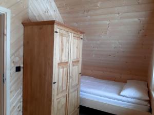 a small room with a bed in a wooden cabin at Koziniec ski & chill in Czarna Góra