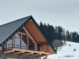 a building in the snow with people on a ski slope at Koziniec ski & chill in Czarna Góra
