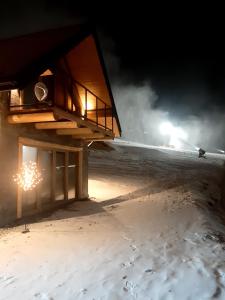 a house on the beach at night with lights at Koziniec ski & chill in Czarna Góra +2 photos