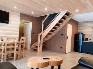 a living room with a spiral staircase and a table at Koziniec ski & chill in Czarna Góra