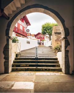 an archway with stairs leading up to a building at Hotel Restaurant Elissaldia in Bidart