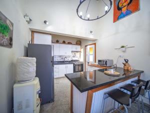 a kitchen with a refrigerator and a counter top at Colonial 2BR Apartment 2 mins walk to beach in Sosúa