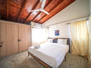 a bedroom with a bed with a ceiling fan at Colonial 2BR Apartment 2 mins walk to beach in Sosúa