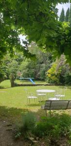 a picnic table and benches in a park at Studio, chambre d'hôtes dans mas provençal in Sauzet