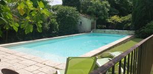 a swimming pool with a chair and a table at Studio, chambre d'hôtes dans mas provençal in Sauzet