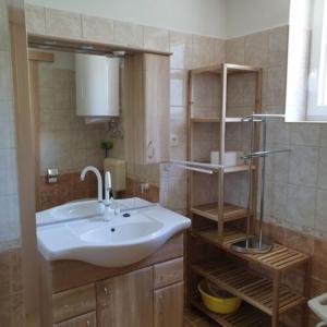 a bathroom with a sink and a mirror and shelves at Villa Bella in Szántód +14 photos