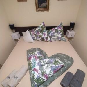 a bed with a heart shaped pillow and pillows at Villa Bella in Szántód
