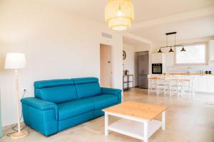 a living room with a blue couch and a table at Moderno Mediterraneo in Alberobello