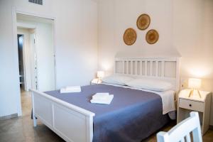 a bedroom with a large bed with two towels on it at Moderno Mediterraneo in Alberobello