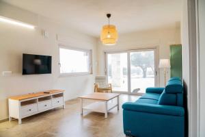 a living room with a blue couch and a table at Moderno Mediterraneo in Alberobello
