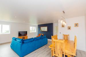 a living room with a blue couch and a table at Buzzards Retreat in Tiverton