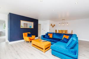 a living room with a blue couch and two orange chairs at Buzzards Retreat in Tiverton