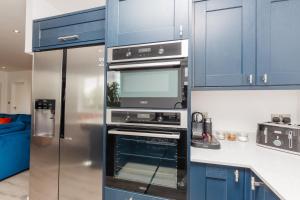 a kitchen with a stainless steel refrigerator and an oven at Buzzards Retreat in Tiverton +21 photos
