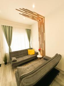 a living room with a couch and a large mirror at VIBE S31 Apartman ,AC,Free Parking in Székesfehérvár