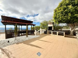 a patio with a pavilion and a fence and a tree at Villa Tequila in Tijoco de Abajo