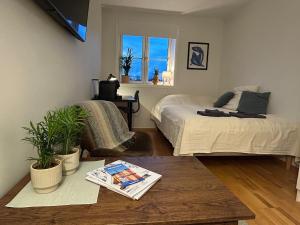 a bedroom with two beds and a table and a window at Central-Trondheim Riverside Studio-Apartment in Trondheim