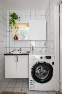 a kitchen with a washing machine and a sink at Central-Trondheim Riverside Studio-Apartment in Trondheim