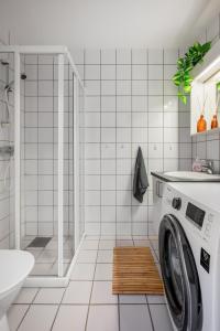 a white bathroom with a washing machine in it at Central-Trondheim Riverside Studio-Apartment in Trondheim +18 photos